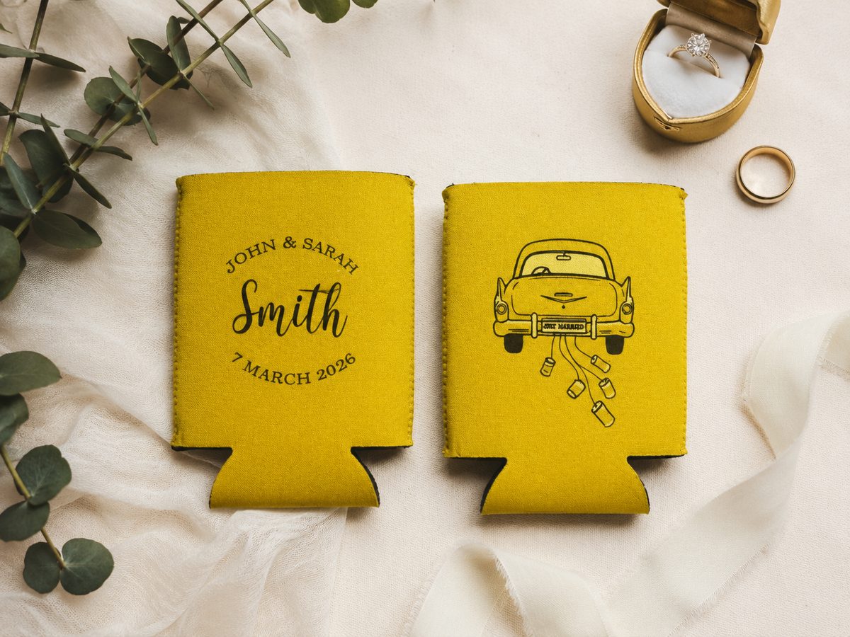 Gold foldable stubby holders with a wedding monogram on one side and a just-married car on the other
